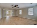 Spacious living room boasts hardwood floors, a modern ceiling fan, and glass doors to another room at 4131 Carroll Sw St, Covington, GA 30014