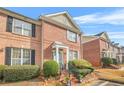 Two-story brick townhouse with well-manicured landscaping and a welcoming front porch at 1976 Drennon Ave, Austell, GA 30106
