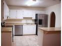 Bright kitchen with an island, tile floors, and stainless steel appliances at 3736 Soapstone Rd, Decatur, GA 30034