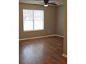Bright bedroom with ceiling fan, light walls, and beautiful, dark laminate wood flooring at 4233 Viewpoint Ln, Ellenwood, GA 30294