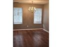 Traditional dining room with two windows, laminate wood floor, and classic chandelier at 4233 Viewpoint Ln, Ellenwood, GA 30294