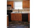 Traditional kitchen with wood cabinets, black appliances, and mosaic tile flooring at 4233 Viewpoint Ln, Ellenwood, GA 30294