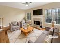 Cozy living room with a fireplace, two chairs, a sofa, and large windows at 155 Mine Run, Fayetteville, GA 30215