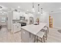Modern kitchen featuring white cabinets, stainless steel appliances, quartz countertops, and a spacious island with seating at 3606 Silvery Way, Powder Springs, GA 30127