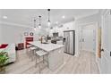 Modern kitchen with white cabinets, quartz island, stainless steel appliances and breakfast bar seating with view to living area at 3606 Silvery Way, Powder Springs, GA 30127