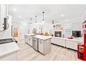 Bright, open-concept kitchen with stainless steel appliances, large island, and view of the living room fireplace at 3606 Silvery Way, Powder Springs, GA 30127