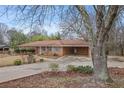 Ranch-style brick home with a spacious driveway and mature trees in a serene neighborhood setting at 3948 Bright Star Rd, Douglasville, GA 30135