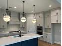 Modern kitchen with white cabinets, stainless steel appliances, a center island, and pendant lighting at 1209 Lakeside Overlook, Canton, GA 30114