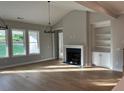 Bright living room with hardwood floors, a fireplace, built-in shelves, and large windows at 1209 Lakeside Overlook, Canton, GA 30114