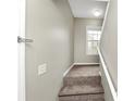Carpeted staircase leading to the upper level, accented by a bright window at 6422 Pinebark Way, Morrow, GA 30260