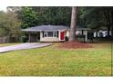 Inviting single-story home with an attached carport and mature landscaping at 5901 Club Se Dr, Mableton, GA 30126