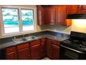 Well-lit kitchen features stainless steel appliances, a double sink and rich wood cabinetry at 5901 Club Se Dr, Mableton, GA 30126
