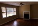 Bright living room featuring hardwood floors, a fireplace, and large windows at 5901 Club Se Dr, Mableton, GA 30126