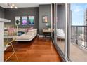Open-concept space with hardwood floors, offering a living area and office with balcony access at 1080 Peachtree Ne St # 2108, Atlanta, GA 30309