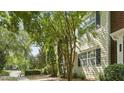A lush tree partially obscures a charming two-story home with black shutters on the windows at 1202 Charleston Ct Cir, Woodstock, GA 30188
