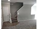 Bright living room featuring neutral paint, plush carpeting and a staircase that leads to the second floor at 1202 Charleston Ct Cir, Woodstock, GA 30188