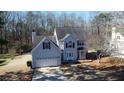 Aerial view of a two-story home featuring a two-car garage and mature trees at 2812 Lake Vista Dr, Buford, GA 30519