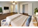 Staged main bedroom featuring hardwood floors, ceiling fan, and ensuite bathroom at 1641 Pendley Dr, Austell, GA 30168