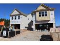 A new construction two-story home with a two-car garage is displayed, under blue skies at 1975 William Glen St, Dacula, GA 30019