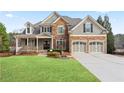 Charming two-story home with stone accents, a manicured lawn, and a two-car garage at 3130 Kates Nw Way, Kennesaw, GA 30152