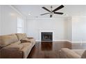 Cozy living room with a fireplace, plush sofa, and dark hardwood floors at 4085 Amberly Nw Grn, Kennesaw, GA 30144