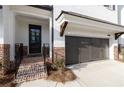 New townhome with white brick, black door and a attached garages at 704 Dodd Ln # 158, Buford, GA 30518