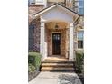 Inviting covered entrance with stone steps, brick columns, and a stylish hanging light at 6304 Long Island Drive, Sandy Springs, GA 30328