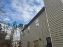 Back exterior shows siding, boarded windows and door with scattered glass at 6357 Polar Fox Ct, Riverdale, GA 30296