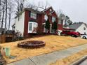 Traditional brick home showcasing the side yard, mature trees, and ample parking space at 3008 Stockbridge Way, Dacula, GA 30019