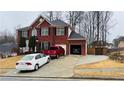 Classic brick home featuring a two car garage, ample parking, and traditional architectural details at 3008 Stockbridge Way, Dacula, GA 30019