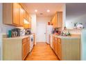 Efficient kitchen layout with wood cabinets and white appliances at 485 Lantern Wood Dr, Scottdale, GA 30079