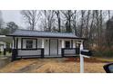 Street-level view of a cozy white home with a charming front porch and well-kept yard at 2322 Ewing Sw St, Atlanta, GA 30331