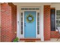 Close-up of a charming blue front door with white trim and a decorative wreath at 243 Wedmore Ct, Suwanee, GA 30024