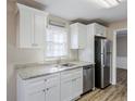 Kitchen featuring white cabinets, granite counters, stainless steel appliances, and a window at 3225 Redona Dr, Atlanta, GA 30349