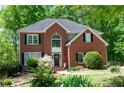 Charming brick residence with a symmetrical facade, black shutters, and lush greenery at 6435 Ivey Creek Cir, Cumming, GA 30040