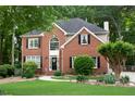Beautiful brick home with lush landscaping, black shutters and a well-manicured lawn at 6435 Ivey Creek Cir, Cumming, GA 30040