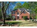 Lovely two-story brick home features an arched window, black shutters, and beautiful landscaping at 6435 Ivey Creek Cir, Cumming, GA 30040