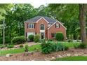 Beautiful two-story home with brick exterior, manicured lawn, and lush landscaping at 6435 Ivey Creek Cir, Cumming, GA 30040