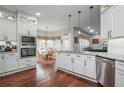 Open-concept kitchen with white cabinets, stainless appliances, and breakfast nook at 6435 Ivey Creek Cir, Cumming, GA 30040
