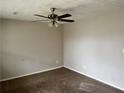This bedroom features neutral walls, carpet and ceiling fan at 304 Deerfield Dr, Jonesboro, GA 30238