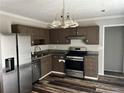 This kitchen features stainless steel appliances, dark cabinets, and laminate flooring at 304 Deerfield Dr, Jonesboro, GA 30238