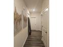 Hallway featuring wood floors, white trim, and accent paintings adding character at 623 Wayland Ct, Fairburn, GA 30213