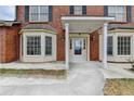 Brick home's front entry features detailed portico, columns, and sidelights framing the front door at 161 Muddy River Rd, Lawrenceville, GA 30043