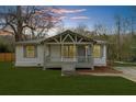 Charming home featuring a covered front porch, manicured lawn, and neutral exterior color scheme at dusk at 2923 Hall Se Dr, Smyrna, GA 30082