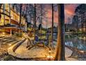 Cozy backyard seating area with a fire pit overlooking the serene lake and lush landscaping at 150 Stone Pond Ln, Johns Creek, GA 30022