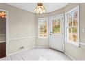 Bright dining area with white door, tile floors, large windows, and decorative light fixture at 3775 Norman Rd, Clarkston, GA 30021