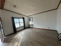 Bright living room featuring wood trim, a large window with curtains, and light-colored floors at 3118 Rockbridge Road Southwest, Avondale Estates, GA 30002