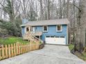 Two-story blue home with a charming white garage door, picket fence, and well-maintained lawn at 2336 Vistamont Dr, Decatur, GA 30033