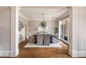 Elegant dining room featuring hardwood floors, decorative pillars, and a modern light fixture at 6955 Laurel Oak Dr, Suwanee, GA 30024