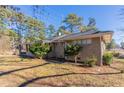 Side view of a single-story brick house, showcasing its simple landscaping and a paved driveway at 3517 Hyland Dr, Decatur, GA 30032